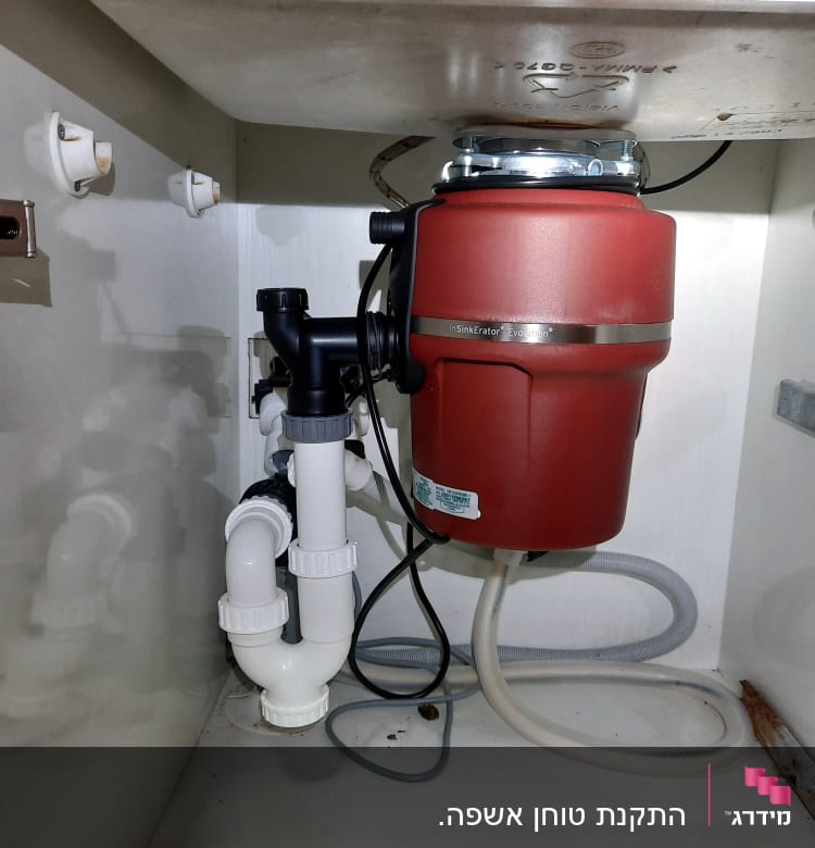 מטחנת אשפה מתחת לכיור עם צינורות פלסטיק